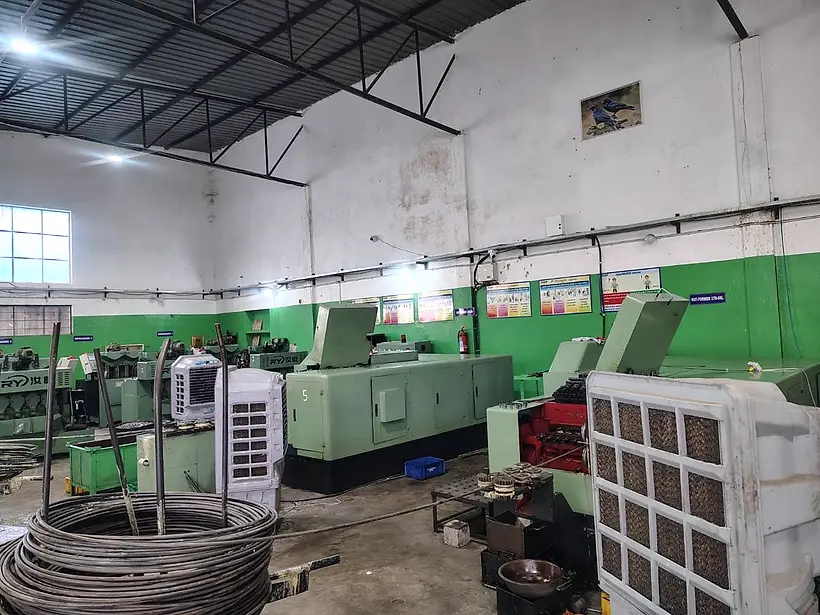 Nut formers with wire coil at the infeed